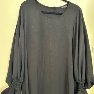 Black straight dress, long sleeves with elastic at the end of the sleeves.